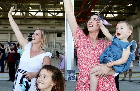 Families wave as squadrons pass over the flight line.